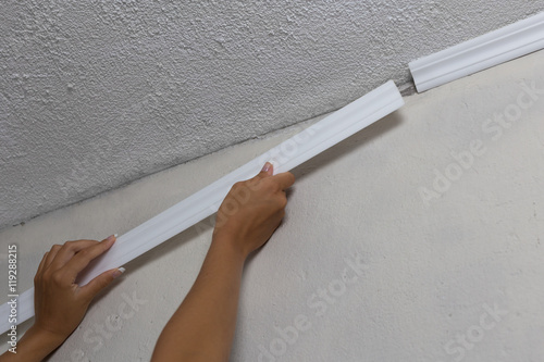 Installing Crown Molding On Ceiling In Room With Painted Wall