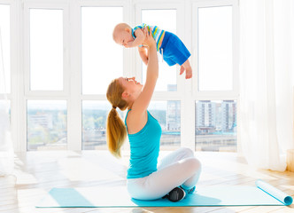 Wall Mural - sports mother is engaged in fitness and yoga with baby at home