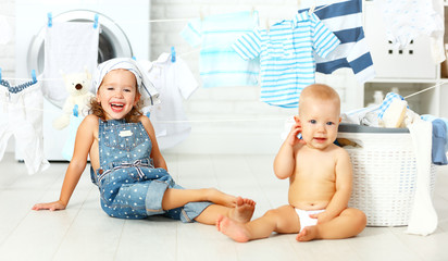 Wall Mural - little helpers funny kids happy sister and brother in laundry to