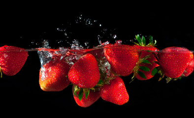 Wall Mural - Strawberries splashing into water