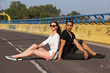 © ginkgofoto - Young attractive couple sitting on a street