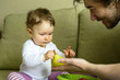 © scaliger - Cute baby girl plays with fruits with her father at home