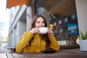 Poster - happy woman drinking cocoa at city street cafe