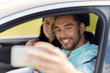© Syda Productions - happy couple in car taking selfie with smartphone