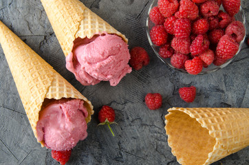 Poster - Raspberry ice cream with ice cream cones on stone table.