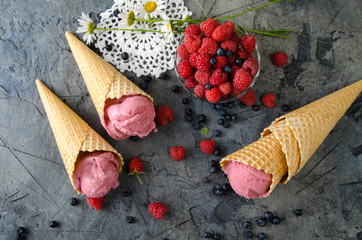 Poster - Raspberry ice cream with ice cream cones on stone table.