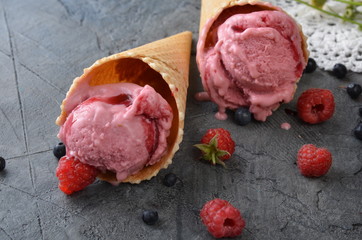 Poster - Raspberry ice cream with ice cream cones on stone table.