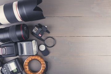 camera photo lenses and accessories on wooden background with co