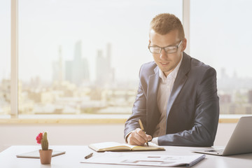 Young man writing in notepad