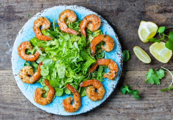 Wall Mural - Seafood shrimp lettuce salad on blue plate