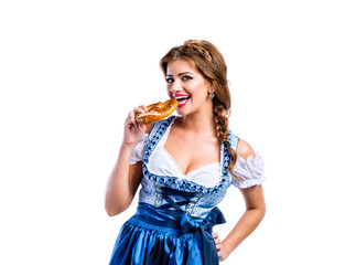 Wall Mural - Beautiful woman in traditional bavarian dress holding a pretzel