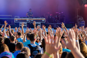 Crowd of fans cheering at open air live music festival