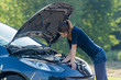 © Racle Fotodesign - frau schaut verzweifelt in den motorraum