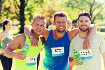 Canvas Print - happy friends with racing badge numbers and water