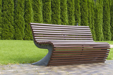 Stylish Curve Shaped Brown Wooden Bench Outdoor Furniture In The Park As Background Image