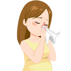  Young pregnant woman with flu sneezing on tissue