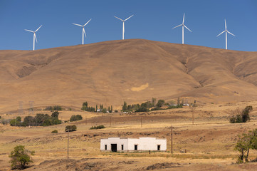 Wind Turbines and Old Building. Spanning 30 miles and offering a capacity of 500 megawatts, Windy Flats development is one of the largest wind energy projects in the United States. Maryhill, WA.