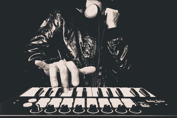 Sticker - professional musician or DJ hand on studio keyboard synthesizer, B&W isolated on black for dance , groove, remix, underground music background concept