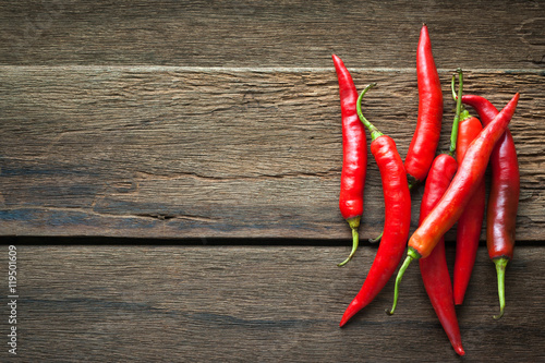 Fotografie, Obraz red chili peppers on dark wooden background
