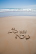 i love you text written on brown sand ground low tide beach ocean seashore in Spain Europe
