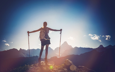 Wall Mural - female mountain climber stands triumphantly at top
