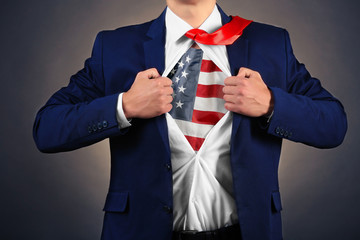 Wall Mural - Businessman showing USA flag under suit on dark background.