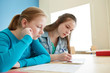 © Syda Productions - student girls with smartphone writing school test