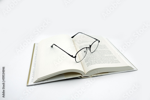 Fotografía Reading Glasses with Open Book on White Background