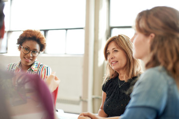 Unposed group of creative business people in an open concept office brainstorming their next project.