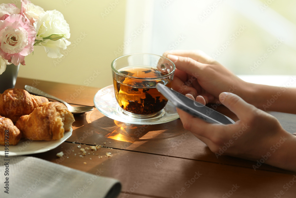 Woman drinking tea with croissants