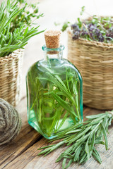 Wall Mural - Bottle of essential rosemary oil or infusion and basket