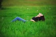 © raisondtre - Beautiful happy young woman lying on the grass, exposing the fac