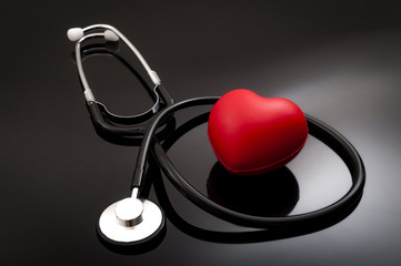 Stethoscope and heart for blood pressure check up on black background