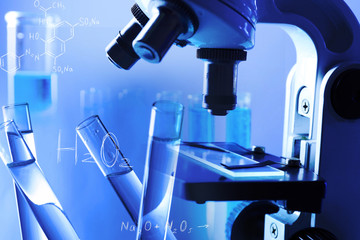 Wall Mural - microscope and test tubes on light blue background