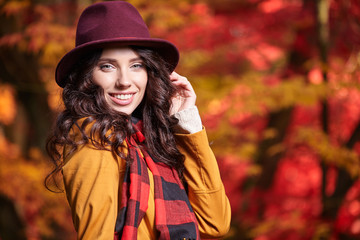 Poster - Fashion woman on a background of red and yellow autumn leaves