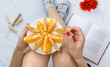 © creativefamily - Woman eating orange fruit in bed