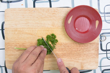 Cutting parsley on a board before cooking