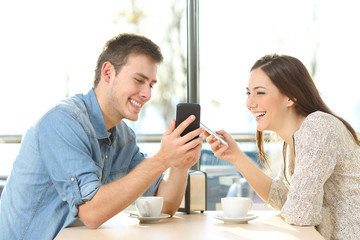 Wall Mural - Couple sharing media content with smart phones