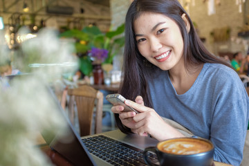 Wall Mural - Asian woman use mobile phone and laptop for business communicati