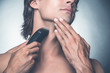 © gstockstudio - Shaving with electric razor.