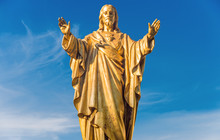 Old Jesus Christ Golden Statue Over Blue Sky