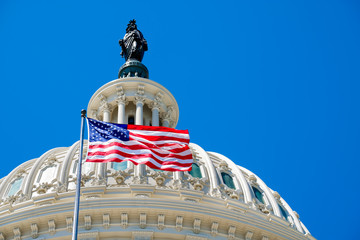 American flag waving in front of the Capitol in Washington D.C.