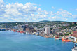Panoramic views with bight blue summer day sky with puffy clouds over the harbor and city of St. John's Newfoundland, Canada.