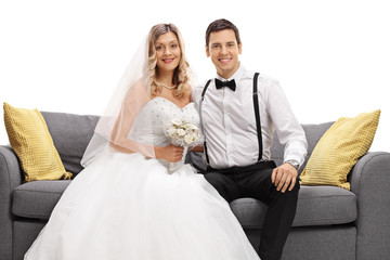 Newlywed couple posing together on a sofa