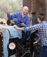 Wall Mural - Two drivers working with tractor