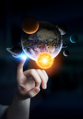 Leinwandbilder - Businesswoman touching solar system with his fingers