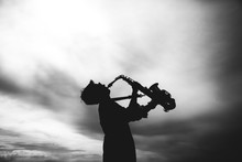 Silhouette Of Young Woman Playing The Saxophone
