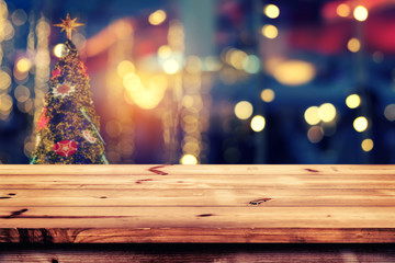 Wall Mural - top of wood table with christmas abstract background light bokeh from xmas tree at night party in wi