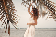 Beautiful Woman In White Dress On Beach. Warm Summer Tones.