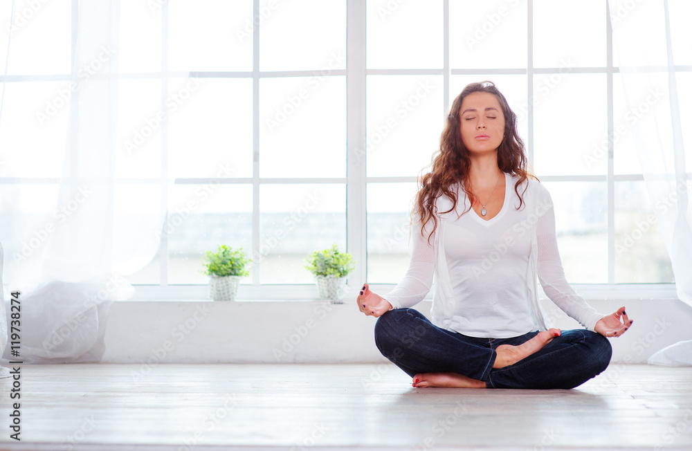 Yoga at home. Keep calm. Attractive young woman sitting on lotus ...